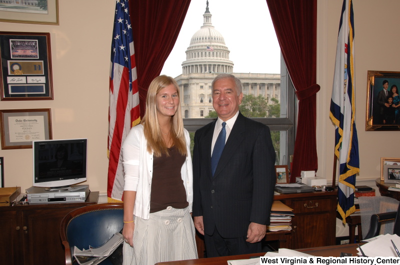 Congressman Rahall stands in his Washington office with a woman wearing a brown shirt and white sweater.