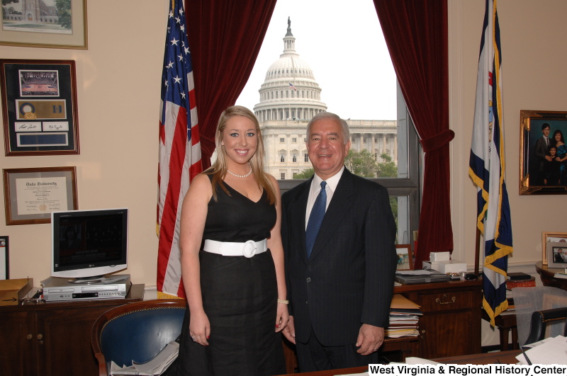 Congressman Rahall stands in his Washington office with a woman wearing a dark dress with white belt.