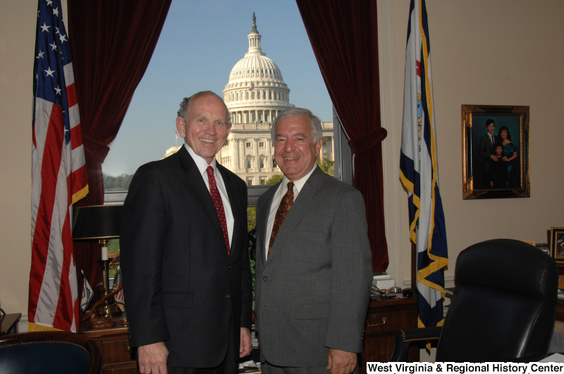 Congressman Rahall stands in his Washington office with a man wearing a dark suit and red tie.