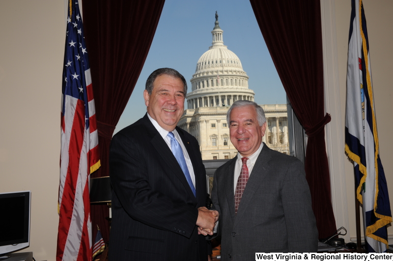 Congressman Rahall stands in his Washington office with a man wearing a dark pinstripe suit and light blue tie.