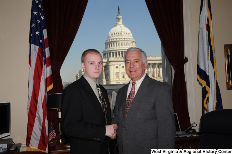 Congressman Rahall shakes hands with a young man in his Washington office.