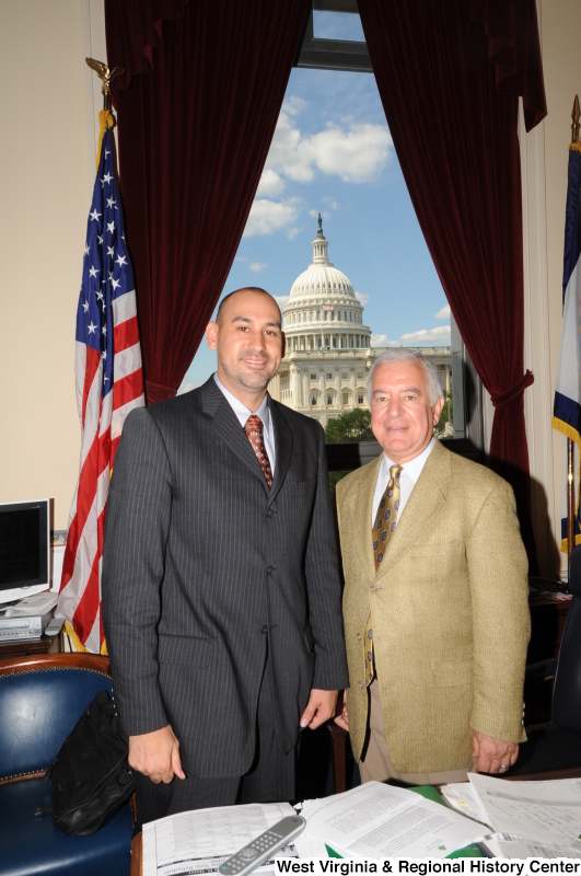 Congressman Rahall stands in his Washington office with a man wearing a grey pinstripe suit.