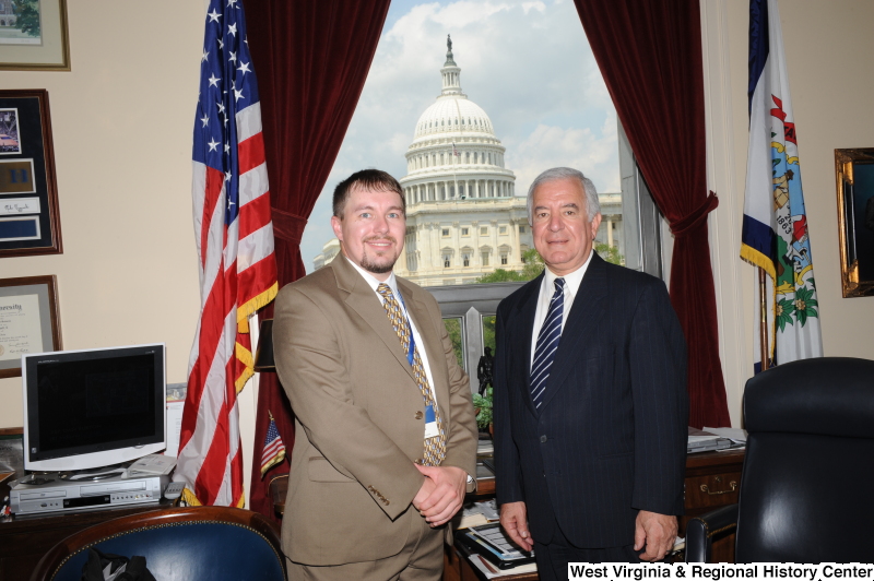 Congressman Rahall stands in his Washington office with a man wearing a light brown suit.