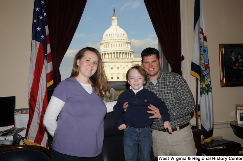 A man, woman, and boy stand in Congressman Rahall's Washington office.