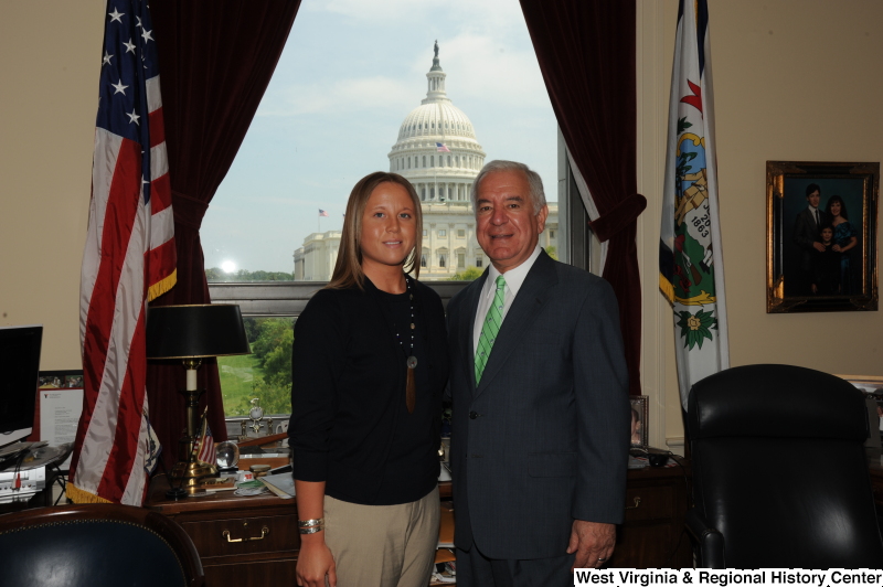 Congressman Rahall stands in his Washington office with a woman wearing a black shirt and necklace.