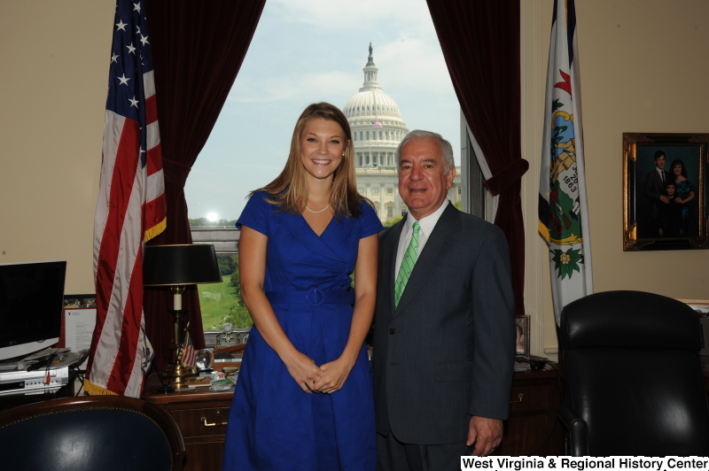 Congressman Rahall stands in his Washington office with a woman wearing a blue dress.