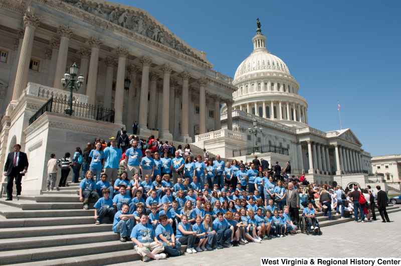 Congressman Rahall stands on the steps of the Capitol Building with children and adults wearing blue "Bradley" shirts.