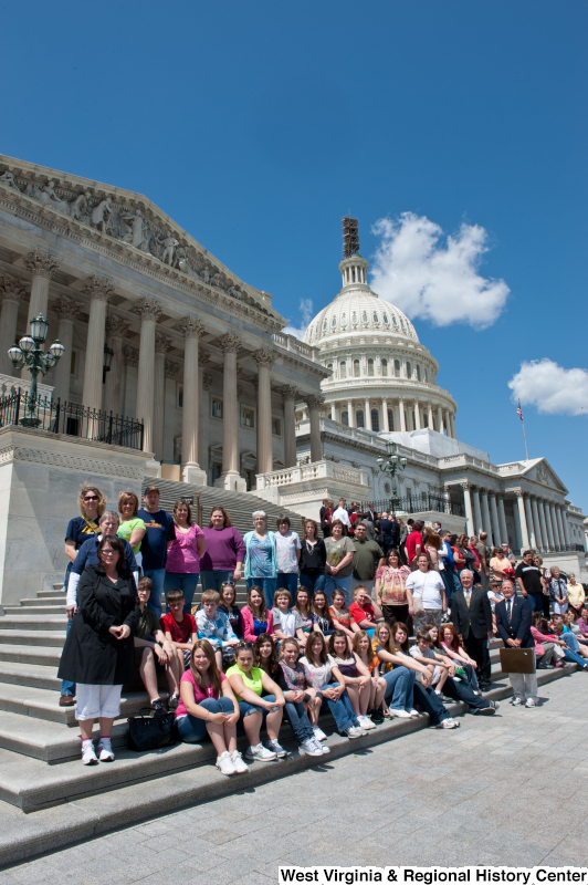 Congressman Rahall stands on the steps of the Capitol Building with adolescents and adults.