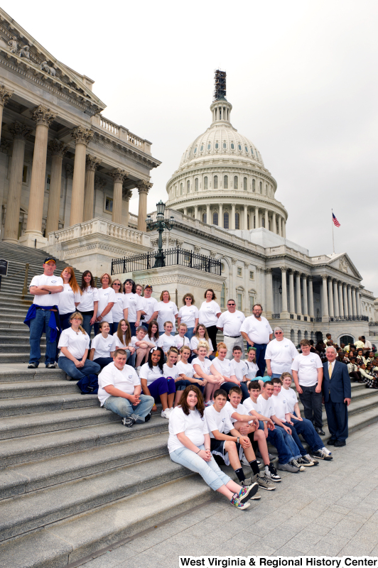 Congressman Rahall stands on the steps of the Capitol Building with adolescents and adults wearing white shirts.