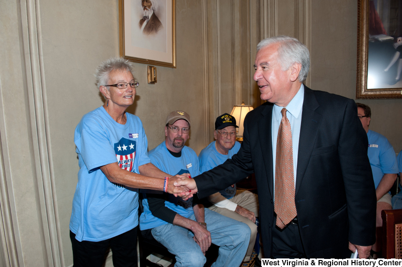 Congressman Rahall shakes hands with a woman at a military award ceremony.