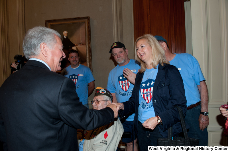Congressman Rahall shakes hands with a woman at a veterans award ceremony.