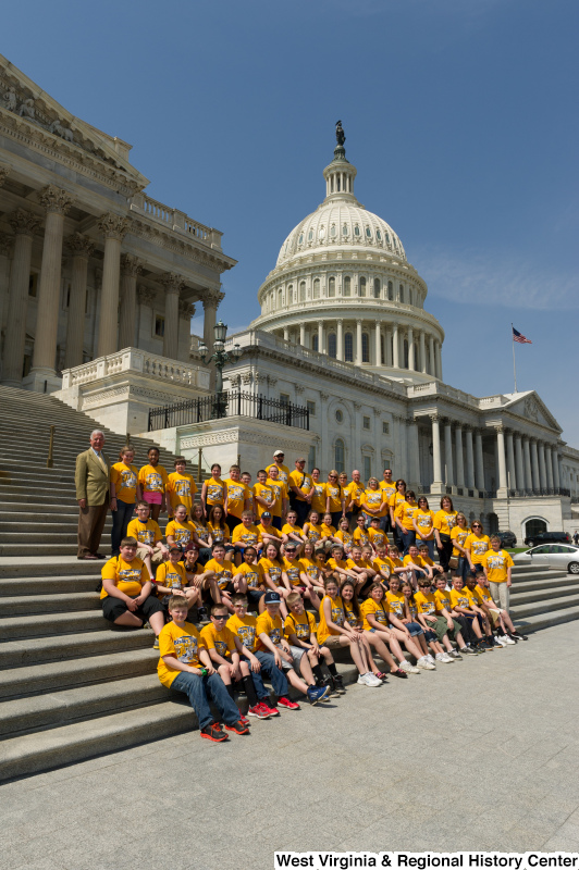 Congressman Rahall stands on the steps of the Capitol Building with children and adults wearing yellow "Bradley Tigers" shirts.