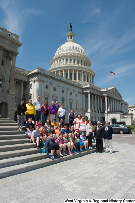 Congressman Rahall stands next to a group of children and adults on the steps of the Capitol Building.