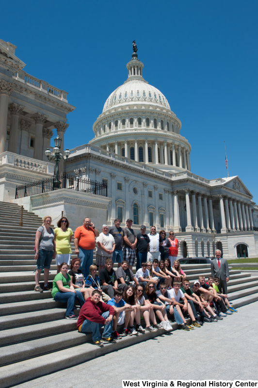 Congressman Rahall stands next to a group of children and adults on the steps of the Capitol Building.