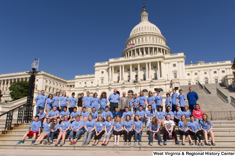 Congressman Rahall stands on the steps of the Capitol Building with children and adults wearing blue shirts labeled "MMS 8th Grade D.C. Trip".