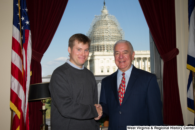 Congressman Rahall stands in his Washington office with a man wearing a grey sweater.