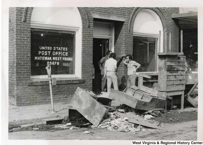 Three unidentified men talking in the doorway of the flood damaged U.S. Postal Office in Matewan, West Virginia.
