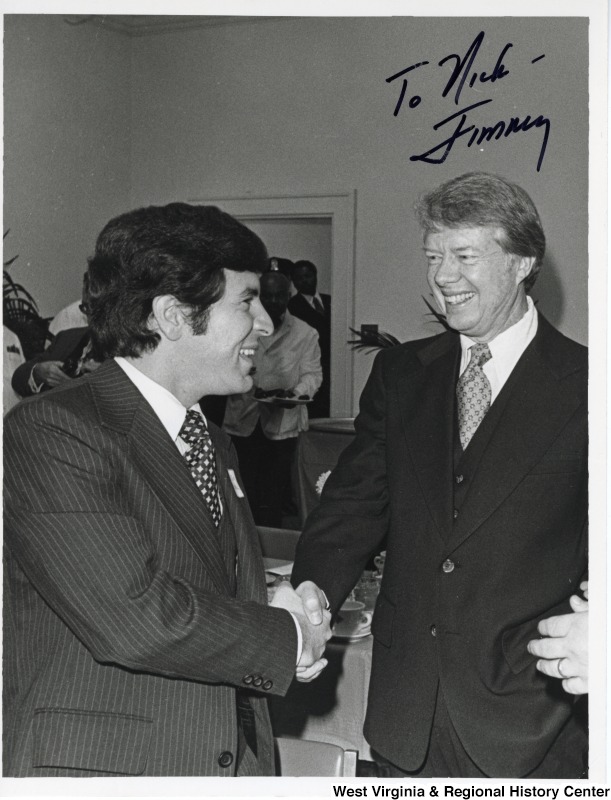 Congressman Nick Rahall II shaking the hand of President Jimmy Carter. The photograph is signed "To Nick - Jimmy."