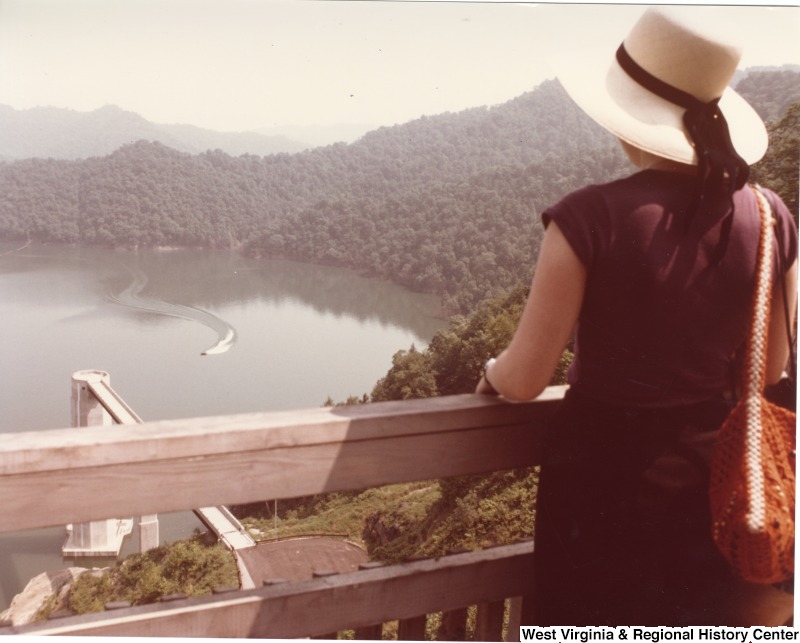 A unidentified woman looking down at a boat on the water