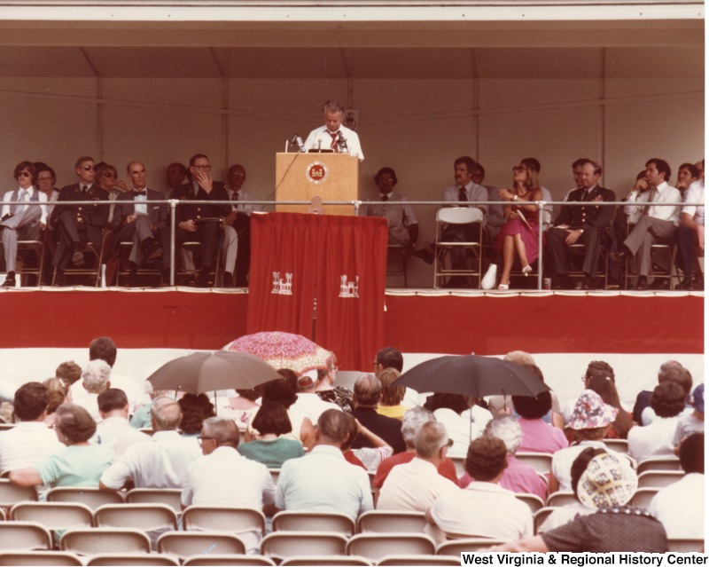 Senator Robert C. Byrd speaking at the R. D. Bailey Dam dedication service in Justine, West Virginia. Congressman Nick Rahall is seated first on the right. Bucky Blackwell, superintendent of the Wyoming County schools is sitting to the left of Byrd (first chair).