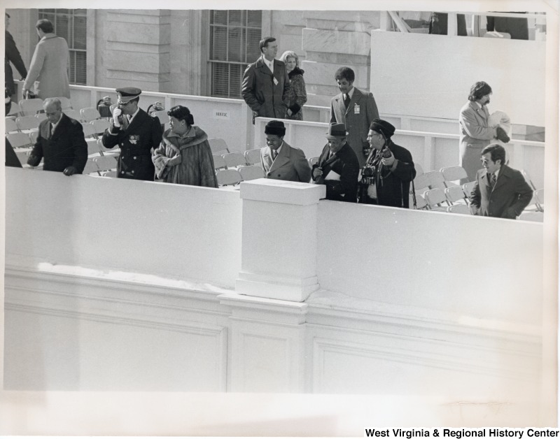 Congressman Nick Rahall II (first on the right) looking over a balcony. There are six unidentified people looking over the balcony with him.