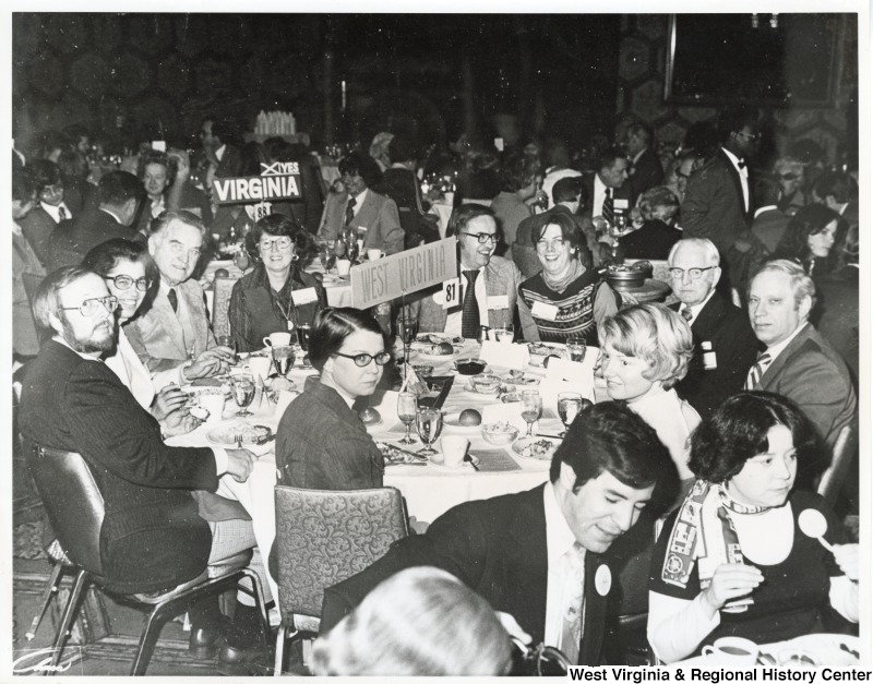 A unidentified group of people sitting at a table labeled "West Virginia." Congressman Nick Rahall II and his first wife, Helen, is seated at a neighboring table. They can be seen in the right corner of the photograph.