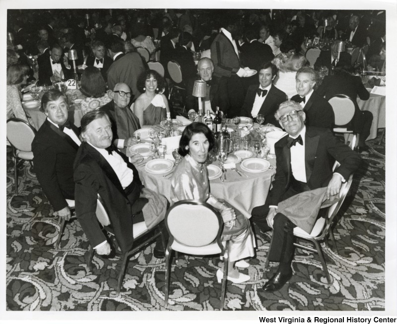 Congressman Nick Rahall II seated at a table with a group of unidentified people.