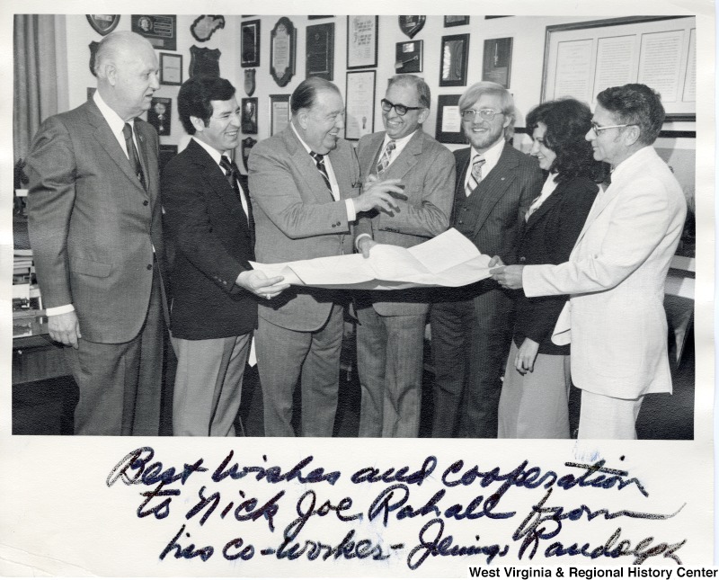 Congressman Nick Rahall (second from the left), Senator Jennings Randolph (third from the left), and five other unidentified people holding a piece of paper between them. The photograph is signed "Best wishes and cooperation to Nick Joe Rahall from his co-worker - Jennings Randolph.'