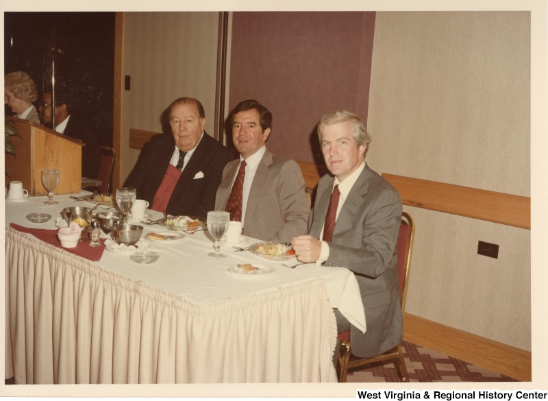 From left to right: Senator Jennings Randolph, Congressman Nick Rahall II, and an unidentified man sitting at a table at a Holiday Inn in Huntington, W.Va.