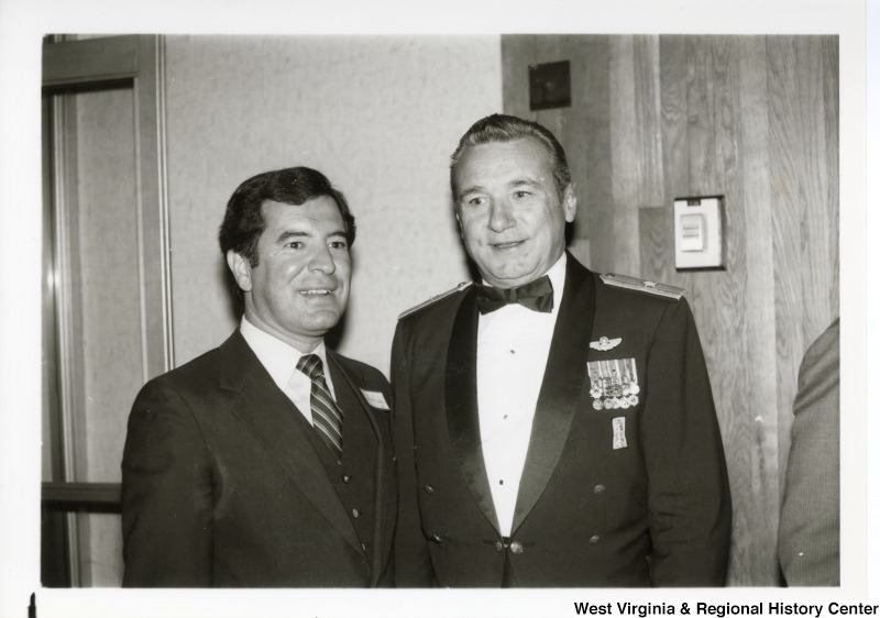 Congressman Nick Rahall II standing with an unidentified man. The man has metals on his jacket.