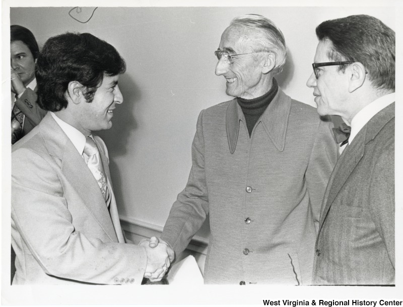 Congressman Nick Rahall (D-WV) shaking Jacques Cousteau's hand. Congressman Paul Simon (D-IL) is standing to the right of Cousteau. Congressman John Breaux (D-LA) is in the back, behind Rahall.