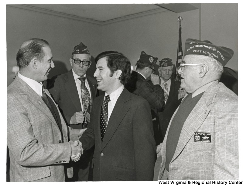 Right to left: Pat Williams from the Veterans of Foreign Wars (VFW) and Congressman Nick Rahall II (D-WV) shaking the hand of an unidentified man.