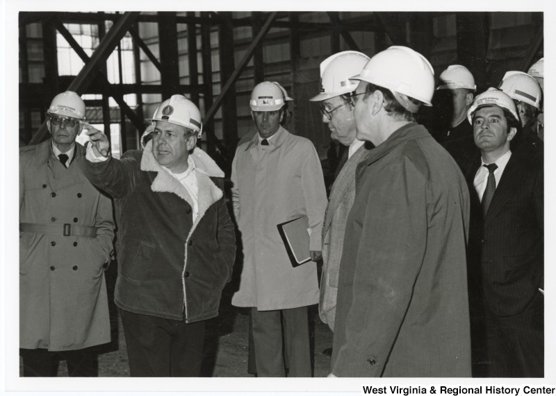 Congressman Nick Rahall II (first on the right) at a factory tour with an unidentified group of people. Congressman Tom Bevill is the first person on the left.