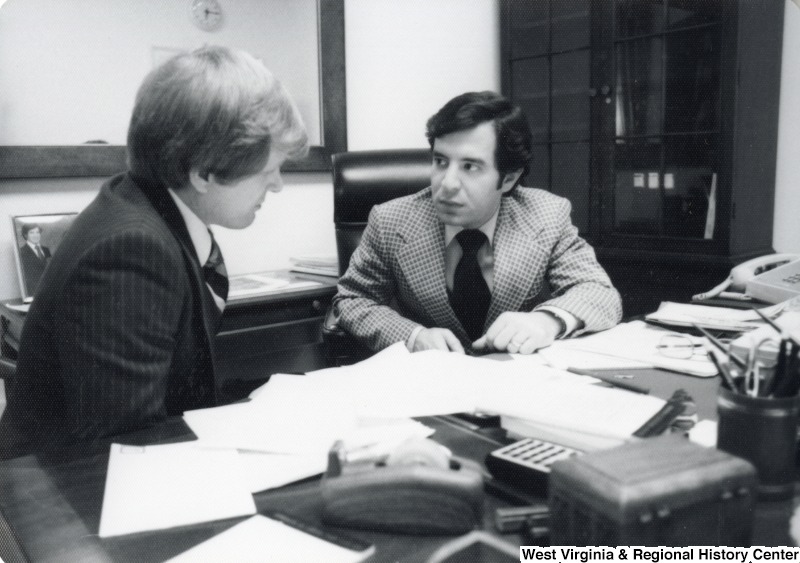 Congressman Nick Rahall II seated at a desk with a unidentified man.