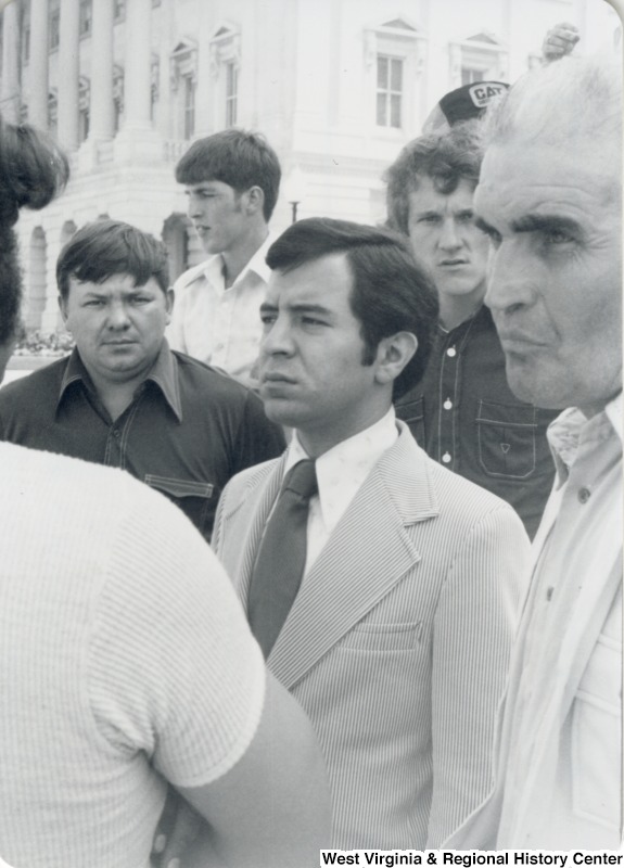 Congressman Nick Rahall II (center) standing with a unidentified group of men.