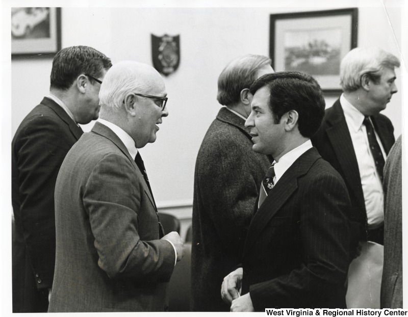 Congressman Nick Rahall II (front right) speaking to David Rodrick at a Steel Caucus Meeting. Three unidentified people are standing behind them.