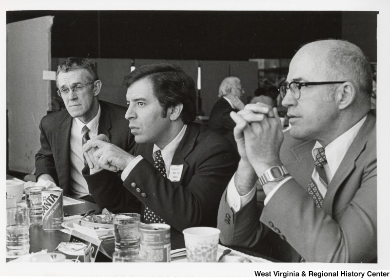 Congressman Nick Rahall II (center) eating with two unidentified men.