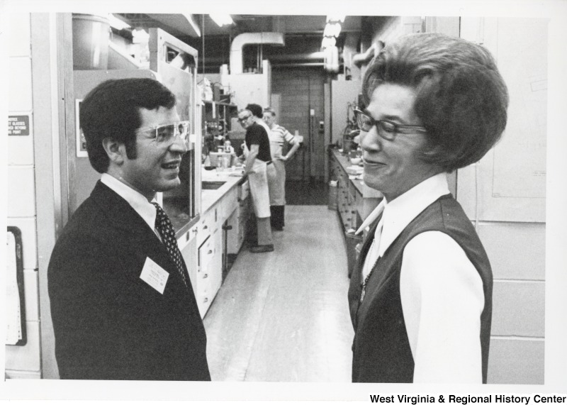 Congressman Nick Rahall II laughing with an unidentified woman from Union Carbide. Three unidentified people can be seen in the backgorund.