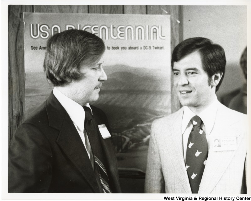 Congressman Nick Rahall II with Bruce Vess in front of a USA Bicentiennial sign.