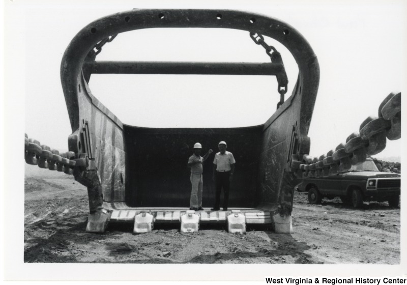Congressman Nick Rahall and Paul Churton standing inside an excavator bucket.