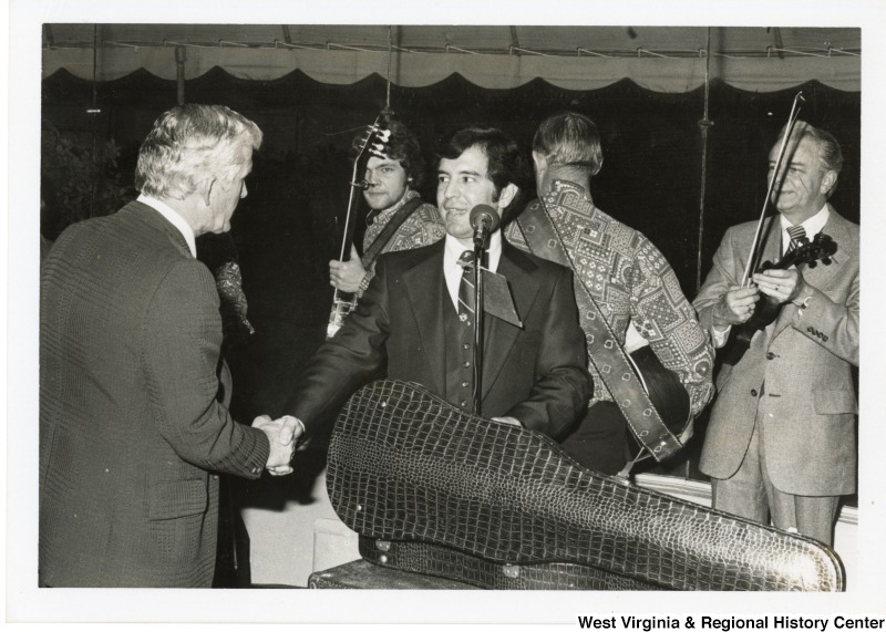 From left to right: Arnold Miller; Congressman Nick Rahall II; and Senator Robert C. Byrd with a fiddle. Two unidentified musicians are behind Congressman Rahall.