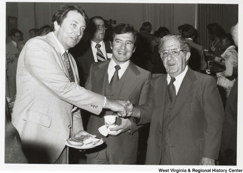 Frank Moore, President Carter's Legislative Liaison, shaking the hand of Congressman Rahall's father, Nick Rahall, at Rahall's 30th birthday fundraising party. Congressman Rahall is standing in between the two.