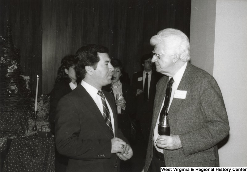 Congressman Nick Rahall II speaking with an unidentified man one of his birthday parties.