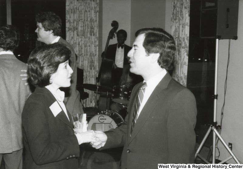 Congressman Nick Rahall II speaking to an unidentified woman at one of his birthday parties.