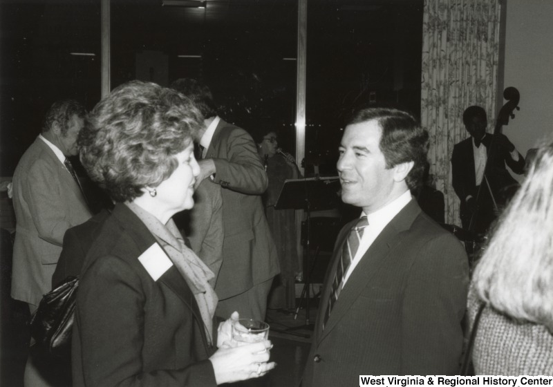 Congressman Nick Rahall II speaking with an unidentified woman at one of his birthday parties.