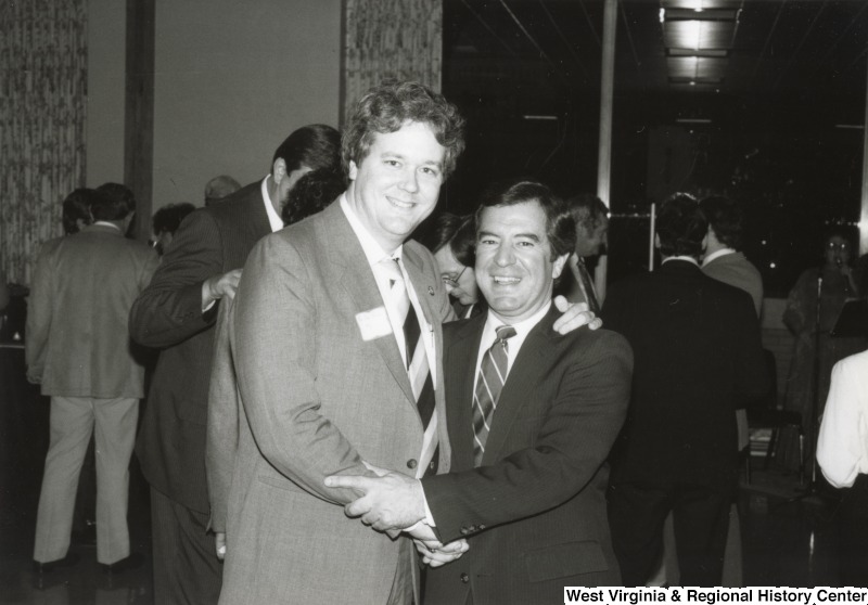 Congressman Nick Rahall II shaking the hand of an unidentified man at one of his birthday parties.
