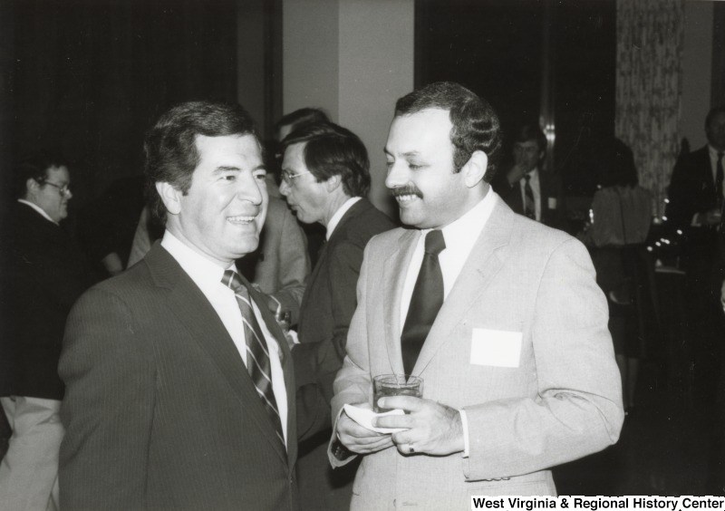 Congressman Nick Rahall II laughing with an unidentified man at one of his birthday parties.