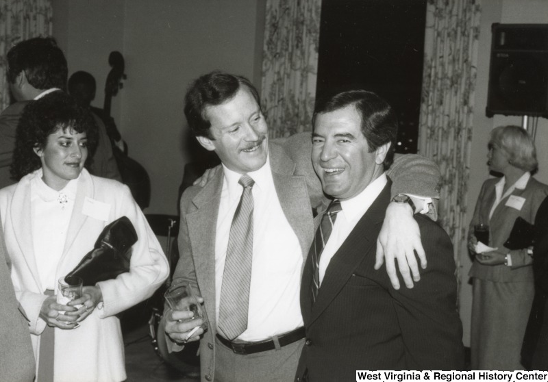 Congressman Nick Rahall II (right) with an unidentified man and woman at his birthday party. The unidentified man has his arm around Rahall.