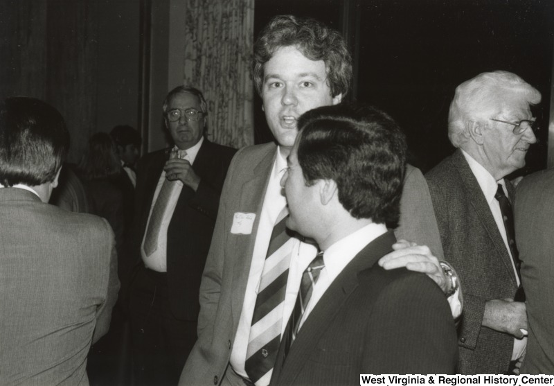 Congressman Nick Rahall II talking to an unidentified man at his birthday party.