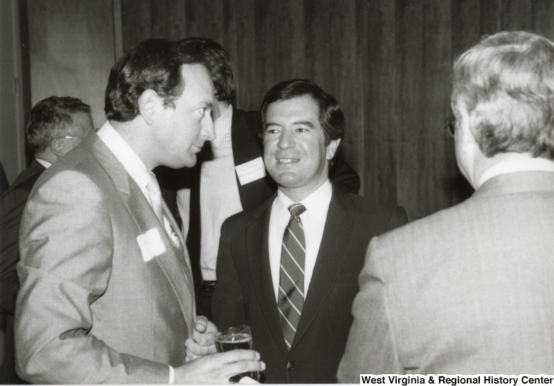 Congressman Nick Rahall II (center) speaking with two unidentified men at his birthday party.